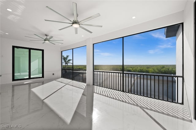 unfurnished sunroom featuring ceiling fan