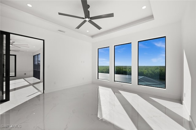 spare room featuring ceiling fan and a tray ceiling