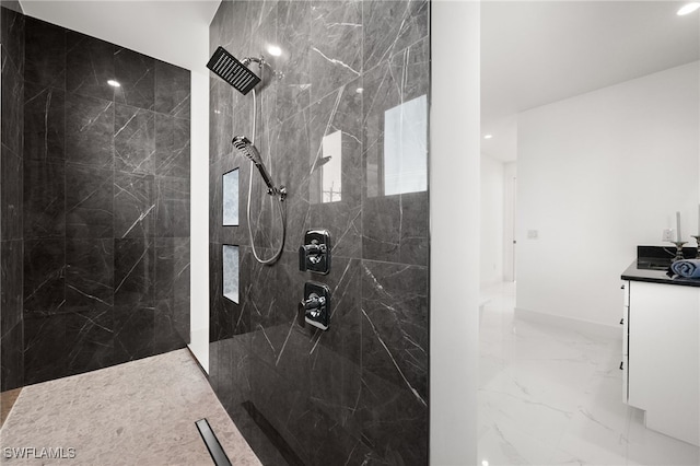 bathroom featuring tiled shower and vanity