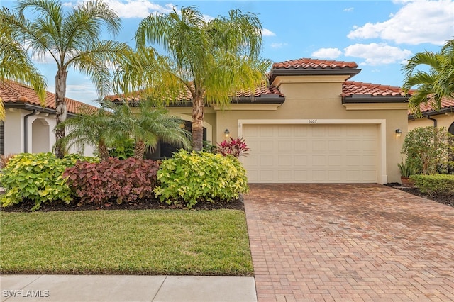 mediterranean / spanish-style home featuring a garage and a front yard