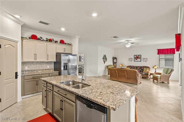 kitchen with tasteful backsplash, an island with sink, sink, ornamental molding, and stainless steel appliances