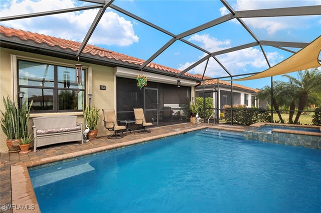 view of pool with a patio area, a sunroom, glass enclosure, and an in ground hot tub