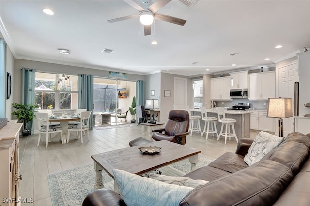 living room with crown molding, ceiling fan, and light hardwood / wood-style floors