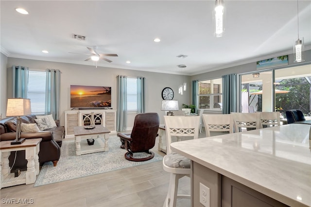 living room with ornamental molding and ceiling fan