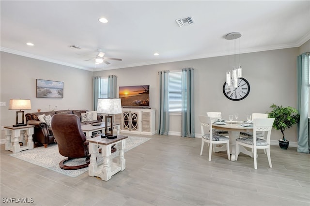 living room featuring ornamental molding, ceiling fan with notable chandelier, and light wood-type flooring