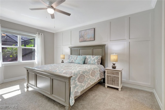 carpeted bedroom with ceiling fan and ornamental molding