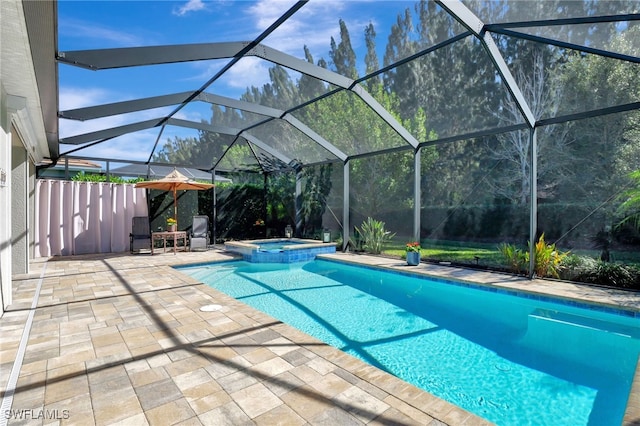 view of swimming pool featuring a patio area, an in ground hot tub, and glass enclosure