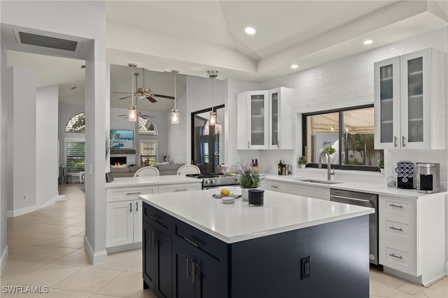 kitchen with sink, stainless steel dishwasher, kitchen peninsula, and a kitchen island