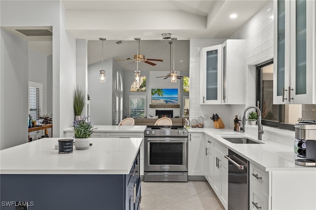 kitchen featuring sink, white cabinetry, light tile patterned floors, appliances with stainless steel finishes, and kitchen peninsula