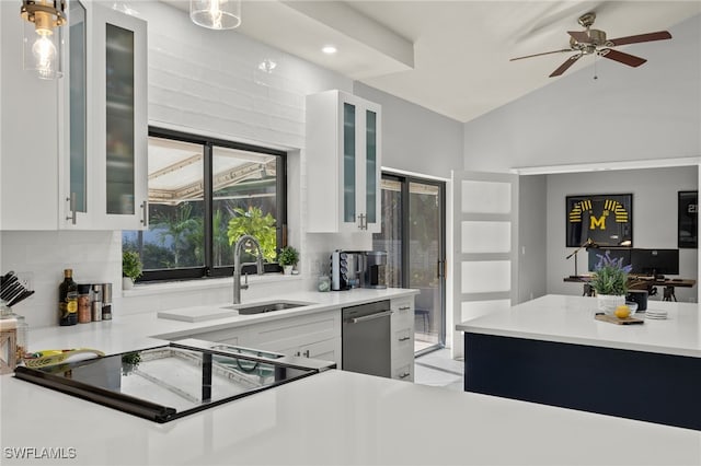 kitchen featuring hanging light fixtures, white cabinetry, lofted ceiling, and sink