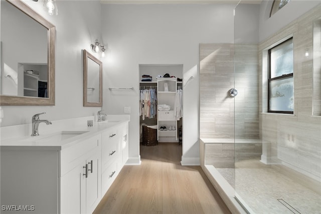 bathroom featuring vanity, hardwood / wood-style flooring, and tiled shower