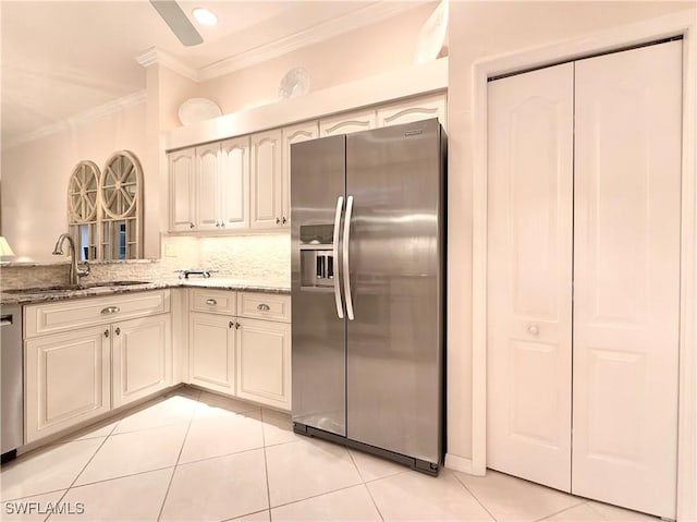 kitchen with sink, light tile patterned floors, appliances with stainless steel finishes, light stone countertops, and decorative backsplash