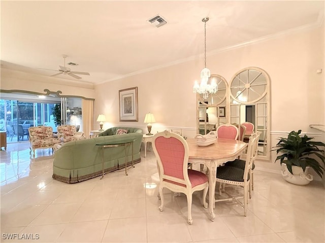 dining space featuring crown molding, ceiling fan with notable chandelier, and light tile patterned floors