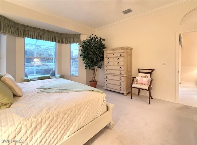 bedroom with ornamental molding and light colored carpet