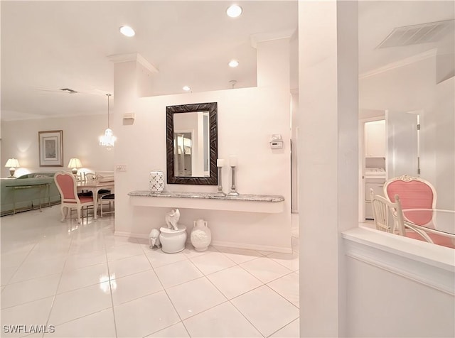 bathroom with ornamental molding, washer / dryer, and tile patterned floors