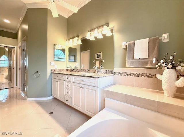 bathroom featuring tile patterned flooring, vanity, ornamental molding, and a bathing tub