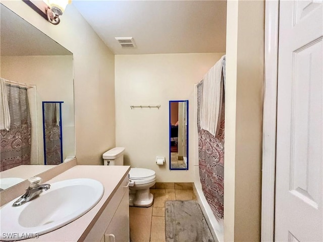 bathroom with tile patterned flooring, vanity, and toilet