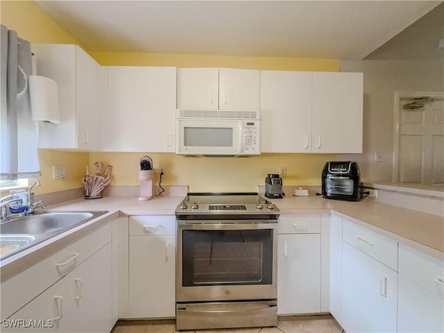 kitchen with white cabinets, sink, and electric range