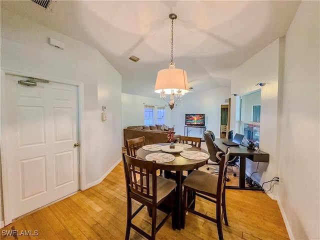 dining room with lofted ceiling, a chandelier, and light hardwood / wood-style flooring