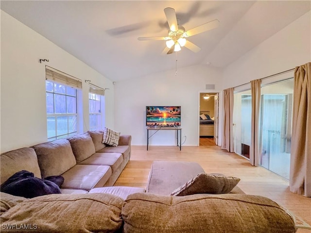 living room with vaulted ceiling, ceiling fan, and light wood-type flooring