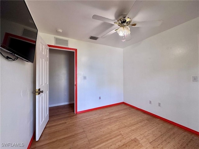 spare room featuring wood-type flooring and ceiling fan