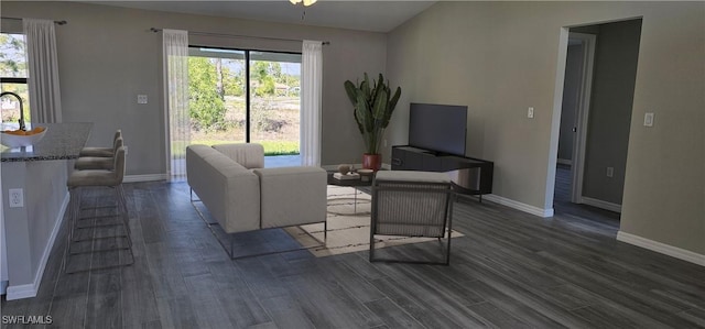 living area with baseboards and dark wood-style floors