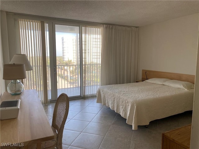 bedroom featuring access to exterior, tile patterned floors, and a textured ceiling