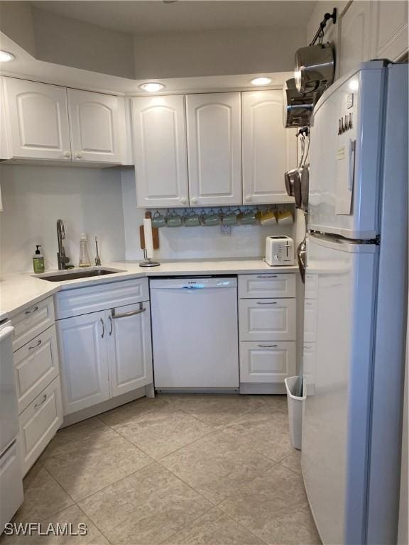 kitchen featuring sink, light tile patterned floors, white cabinets, and white appliances