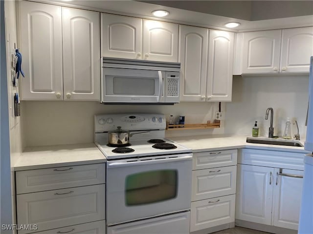 kitchen featuring white appliances, sink, and white cabinets