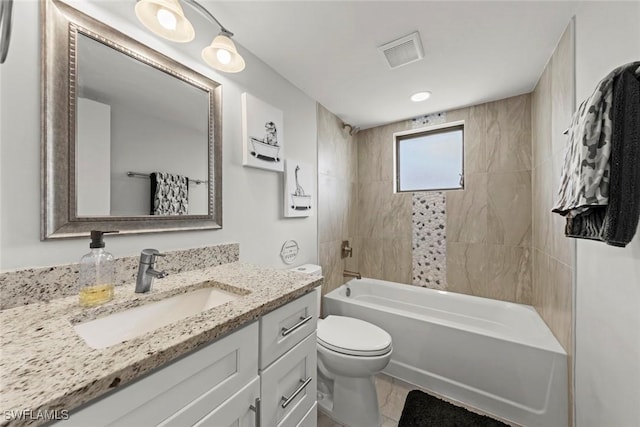 full bathroom with tiled shower / bath, vanity, and toilet