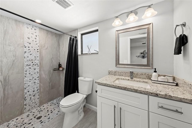 bathroom with walk in shower, vanity, and toilet