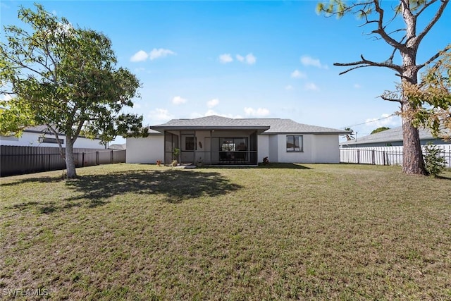 rear view of property featuring a sunroom and a yard