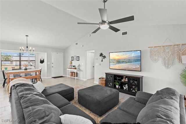 living room featuring lofted ceiling, ceiling fan with notable chandelier, and light wood-type flooring