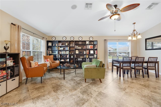 sitting room with lofted ceiling and ceiling fan with notable chandelier