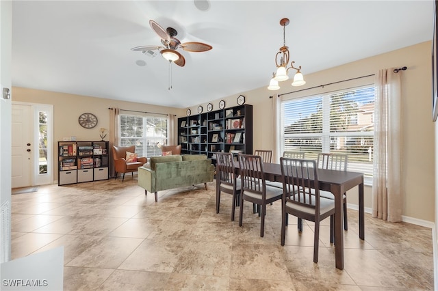 dining area featuring light tile patterned flooring and ceiling fan with notable chandelier