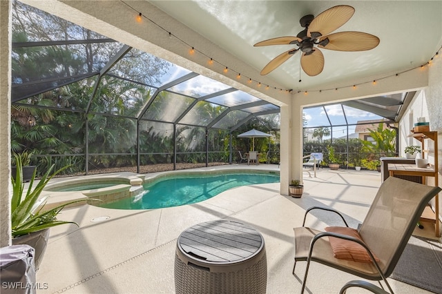 view of pool featuring an in ground hot tub, ceiling fan, a patio area, and glass enclosure