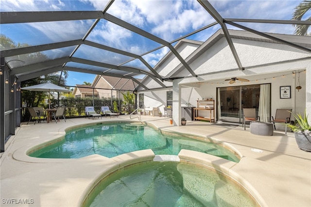 view of swimming pool featuring an in ground hot tub, ceiling fan, glass enclosure, and a patio area