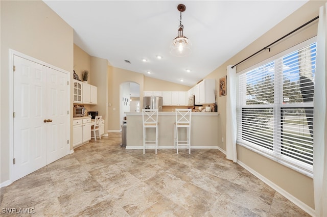 kitchen featuring lofted ceiling, decorative light fixtures, white cabinets, and stainless steel fridge with ice dispenser