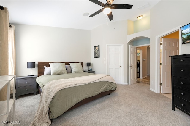 carpeted bedroom featuring a towering ceiling and ceiling fan