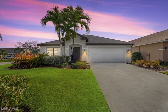 single story home featuring a garage and a lawn