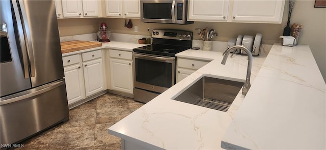 13404 Bristol Park Way, Fort Myers, FL 33913 - kitchen with stainless steel appliances, white cabinets, light stone counters, and stone finish flooring