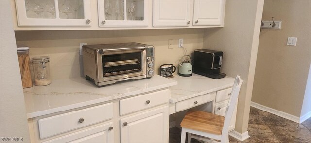 13404 Bristol Park Way, Fort Myers, FL 33913 - kitchen featuring white cabinets, glass insert cabinets, light stone counters, and built in study area