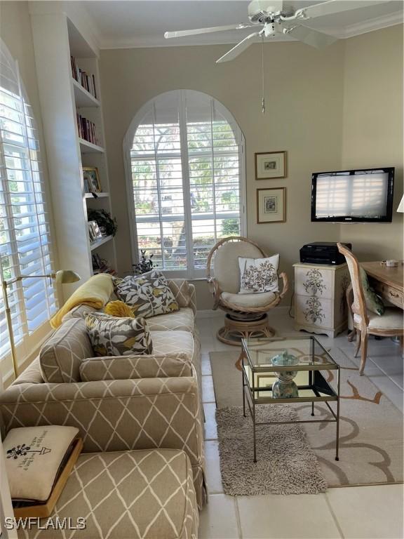 tiled living room featuring ornamental molding and ceiling fan