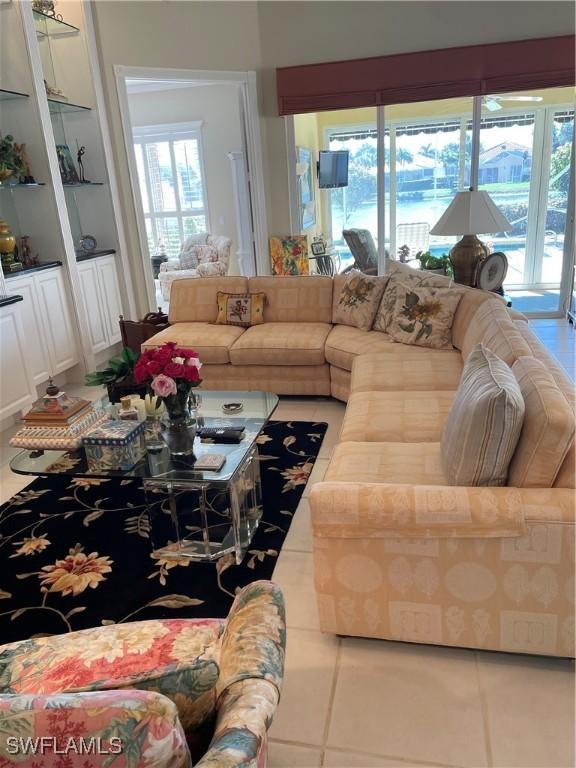 living room featuring built in shelves and tile patterned floors