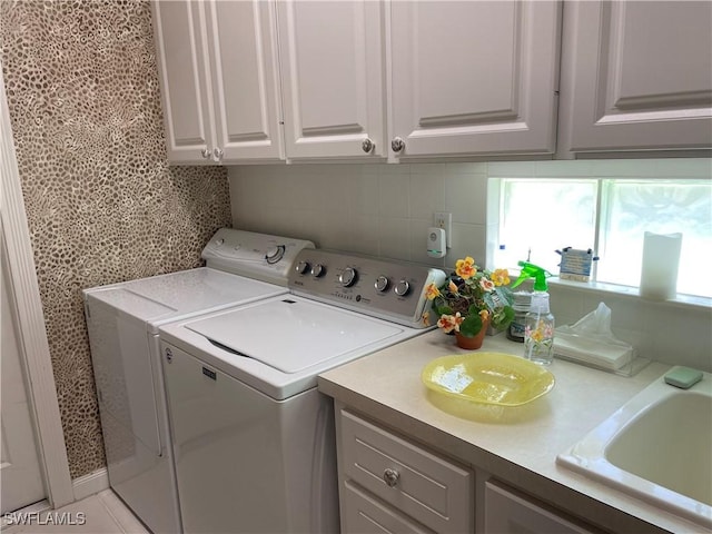 washroom featuring cabinets, sink, and washing machine and clothes dryer