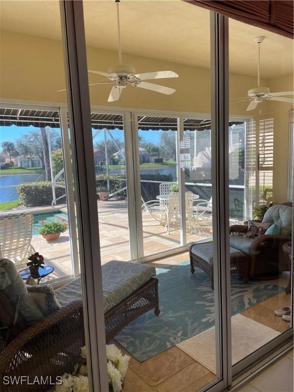 interior space featuring tile patterned flooring, a water view, and ceiling fan