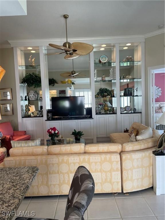 living room with crown molding, light tile patterned floors, and built in shelves