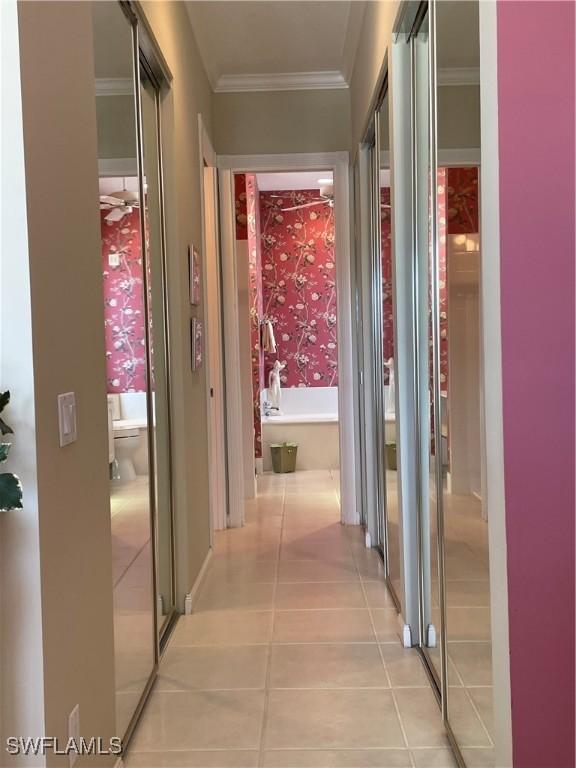 corridor featuring crown molding and light tile patterned flooring