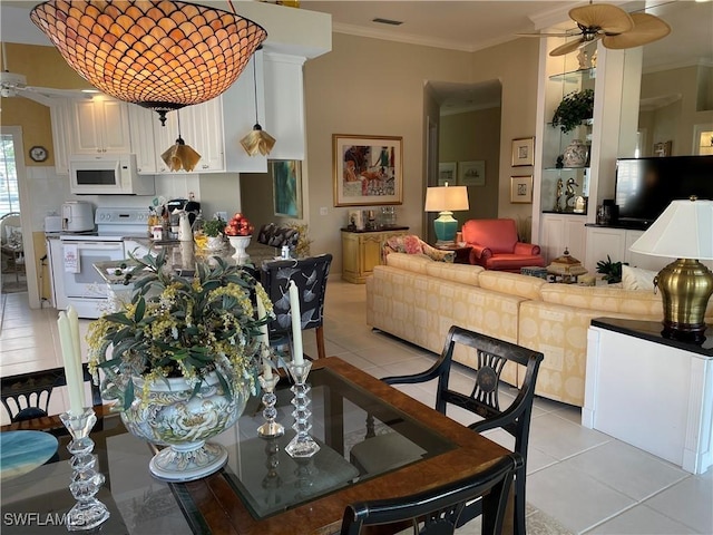 dining area with ceiling fan, ornamental molding, and light tile patterned floors