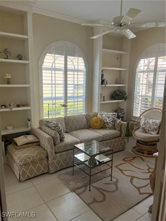 tiled living room with ornamental molding, built in features, and ceiling fan